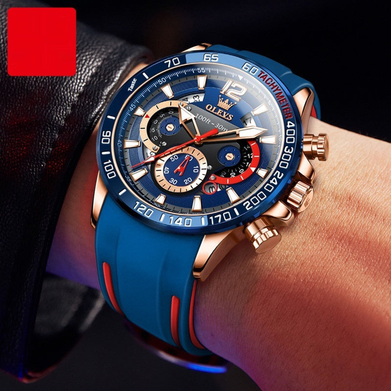 Reloj masculino Olevs con esfera azul, bisel grande en oro rosa y correa de silicona azul. Diseño deportivo con detalles en rojo.