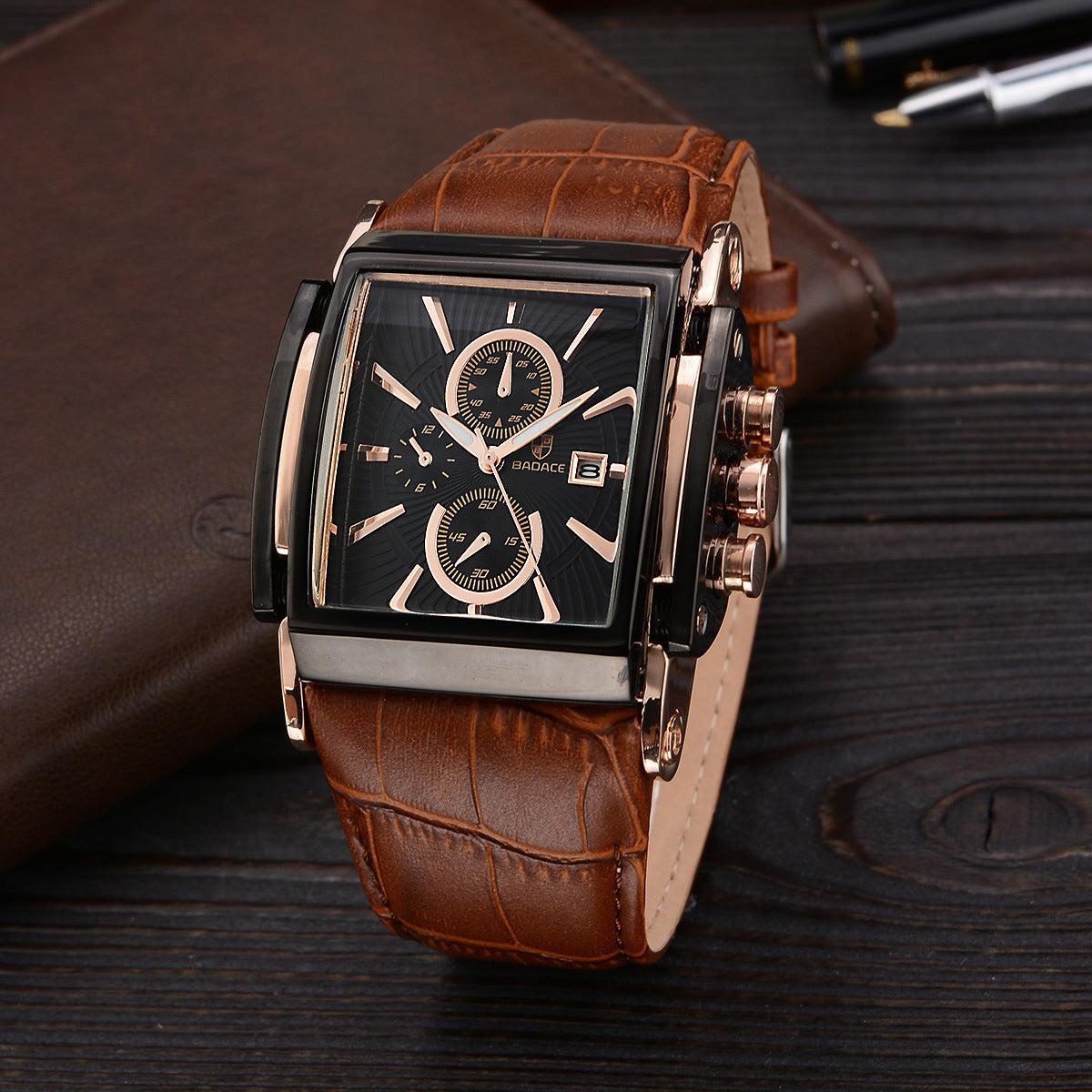 Reloj masculino Badace con esfera rectangular negra, detalles dorados y correa de cuero marrón. Diseño clásico con función de cronógrafo